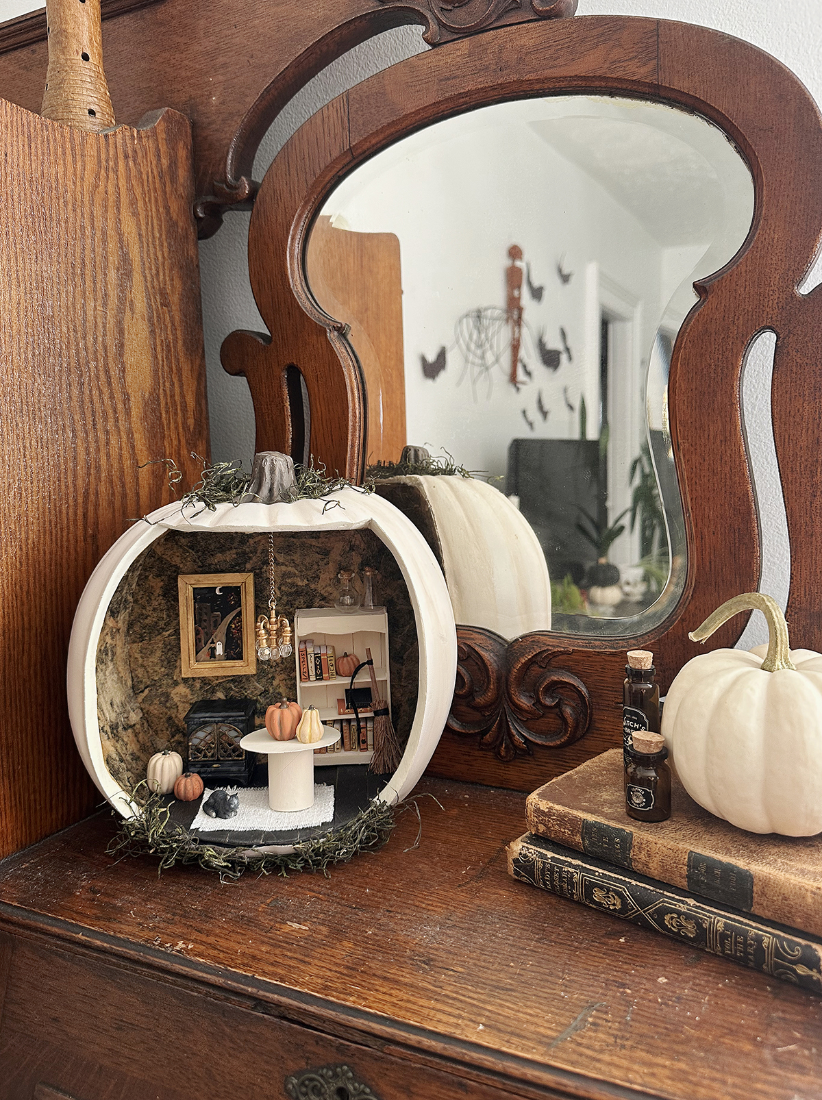 dollhouse pumpkin on wooden shelf with halloween miniature decor inside